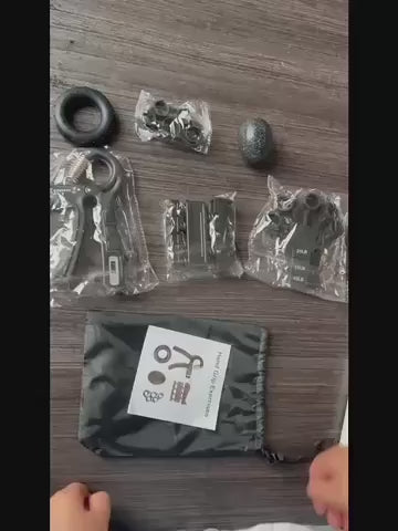 Video som visar innehållet i ett greppstyrkeset, där flera handträningsredskap packas upp och visas på ett bord.