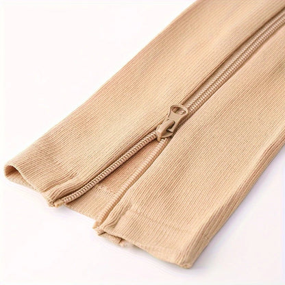 Närbild på dragkedjan på beige stödstrumpor som gör dem enkla att öppna och stänga.