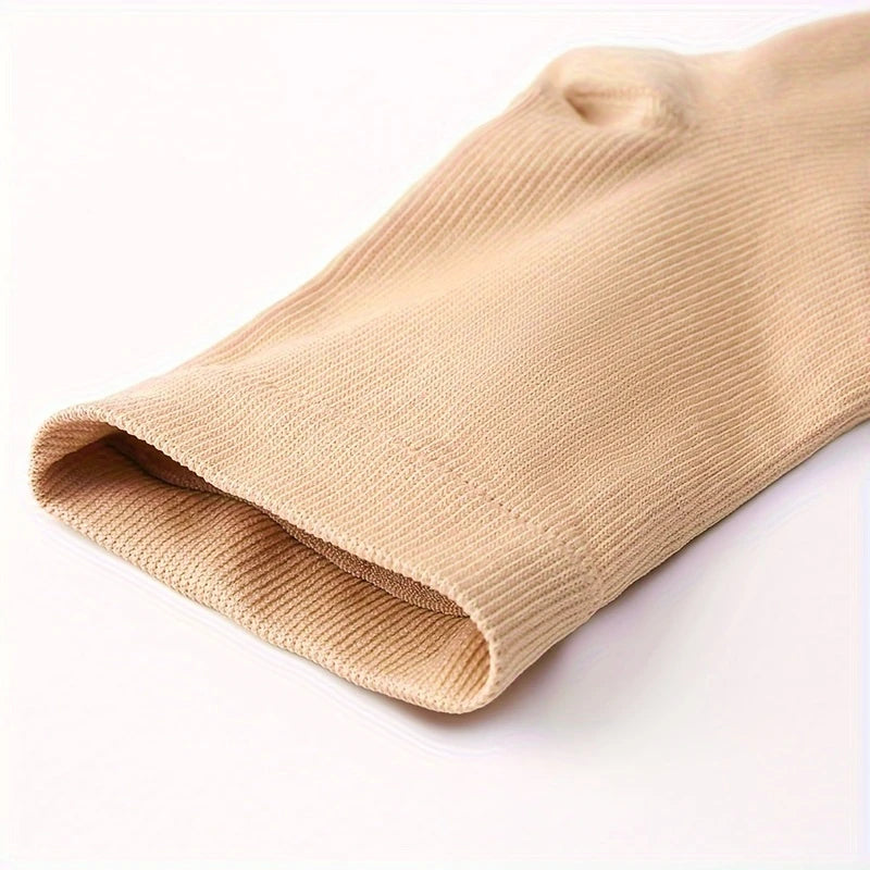 Närbild på den elastiska öppningen på beige stödstrumpor som sitter mjukt mot benet.